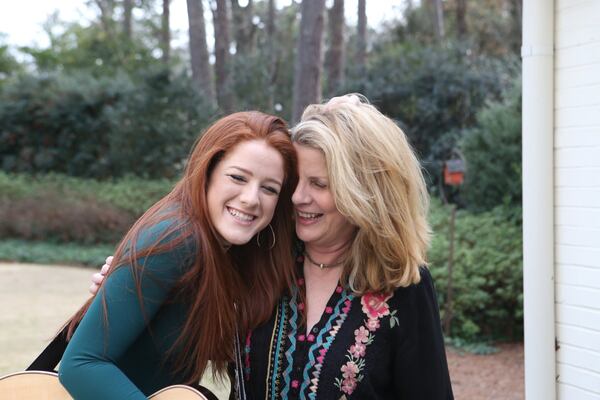 Ella Collier (left), 17, messes around with her mother, Linda Collier, 56, in the backyard of her home in Atlanta. Her mother was at the April 18, 2014, basketball game where Ella collapsed. “When she fell on the court … I couldn’t believe it,” Linda Collier said. “Here I was coming to a basketball game, and my daughter was about to die.” Dr. Dawn Mandeville Brown, who was on the sidelines, jumped into action. HENRY TAYLOR / HENRY.TAYLOR@AJC.COM