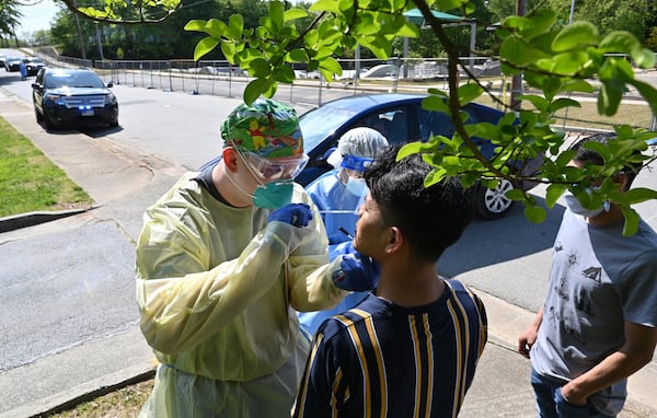 A medical professional collects a nasal swab from a potential COVID-19 patient who just walked in at a drive-through COVID-19 testing site at Good News Clinic in Gainesville on Tuesday, April 28, 2020. HYOSUB SHIN / HYOSUB.SHIN@AJC.COM