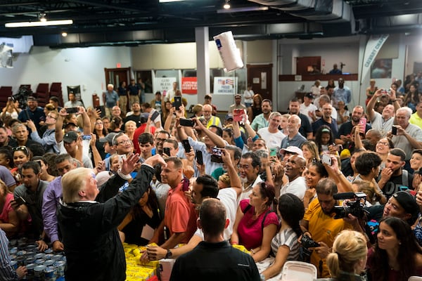 President Donald Trump tosses a roll of paper towels into the crowd at Calvary Church during a visit to survey the impact of Hurricane Maria in San Juan, Puerto Rico, on Oct. 3, 2017. (Doug Mills/New York Times)
                      