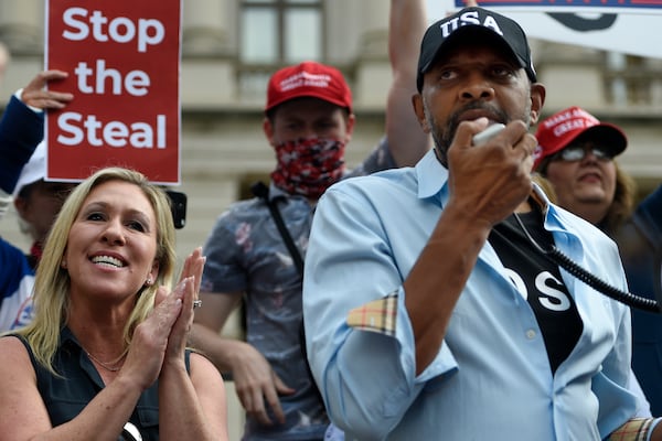 Vernon Jones speaks to supporters of then-President Donald Trump as U.S. Rep. Marjorie Taylor Greene looks on. Jones is now running for a Congress in a district where he does not reside, a tactic Greene adopted before him. (AP Photo/Mike Stewart)