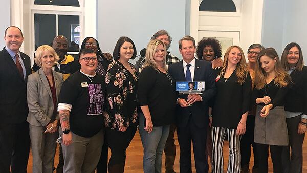 There was not a lot of talk between Gov. Brian Kemp (holding award) and DBHDD Commissioner Judy Fitzgerald (in grey suit, second from left) at Addiction Recovery Awareness Day, where they met five days after her pointed testimony about his proposed budget cuts. The two were among state leaders who spoke to the crowd gathered at the Georgia Freight Depot to discuss addiction recovery across from the state Capitol on Tuesday, Jan. 28, 2020. PHOTO by Ariel Hart / ahart@ajc.com