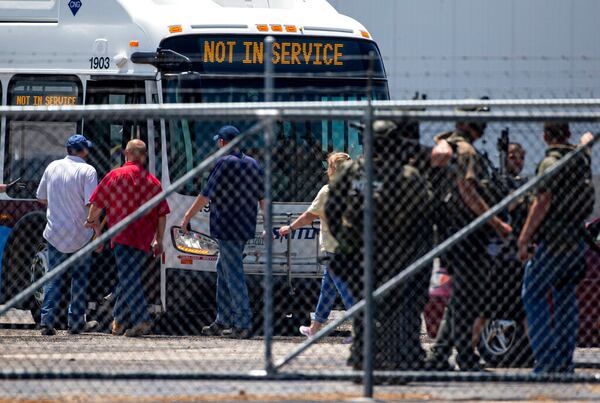 People board an SMTD bus after being cleared from building C1 during an active shooter situation at the Bunn-O-Matic warehouse on Stevenson Drive, Friday, June 26, 2020, in Springfield, Ill. Police say officers are searching for a gunman at a warehouse in the Illinois state capital after at least one person was shot and wounded. (Justin L. Fowler/The State Journal-Register via AP)