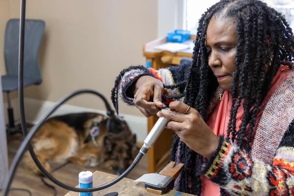 Air Force Veteran Rhonda Lawson prepares to work on jewelry as her service dog Leo sleeps in the corner at Callanwolde Fine Arts Center. 
 PHIL SKINNER FOR THE ATLANTA JOURNAL-CONSTITUTION