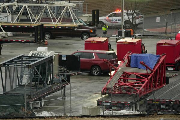 Emergency vehicles are seen across the Potomac River near Ronald Reagan Washington National Airport, Friday, Jan. 31, 2025, in Washington. (AP Photo/Carolyn Kaster)