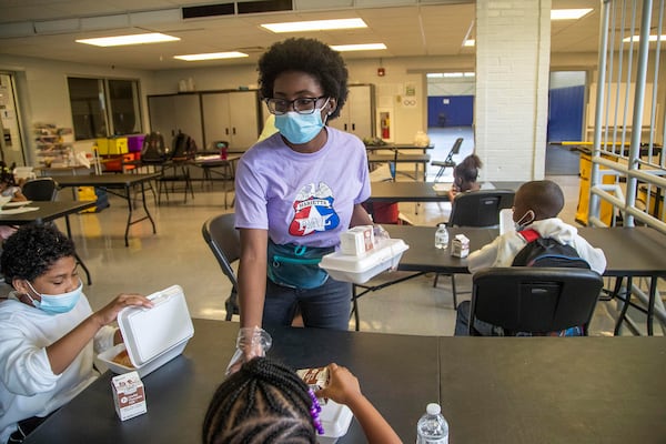 Camp counselor Queen Star Mensah distributes lunches to campers at the Hugh Grogan Community Center in Marietta, Thursday, June 10, 2021. The camp is sponsored by the Marietta Police Athletic League.  (Alyssa Pointer / Alyssa.Pointer@ajc.com)