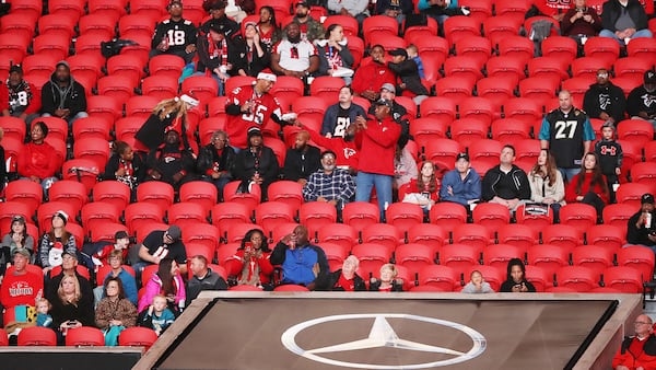 Falcons fans are surrounded by empty seats for the start of the Atlanta Falcons and Jacksonville Jaguars game Sunday, Dec. 22, 2019, at Mercedes-Benz Stadium in Atlanta.