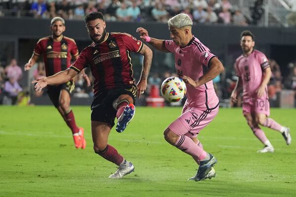 Atlanta United defender Derrick Williams (3) passes the ball as Inter Miami forward Luis Su·rez (9) defends during the second half of their MLS playoff opening round soccer match, Saturday, Nov. 9, 2024, in Fort Lauderdale, Fla. (AP Photo/Lynne Sladky)