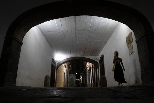 A woman walks in an important Brazilian historical construction from the 18th century named Arco do Teles, in Rio de Janeiro, Friday, Oct. 25, 2024. (Bruna Prado/AP Photo)