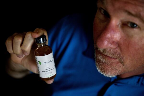 Former Georgia state Rep. Allen Peake, R-Macon, displays a bottle of cannabis oil in his office in Macon.  (AP Photo/David Goldman)