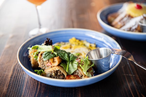 The Breakfast Boys' Green Eggs and Lamb with fried green eggs, lamp empanadas, greens, and chimichurri sauce. (Mia Yakel for The Atlanta Journal-Constitution)