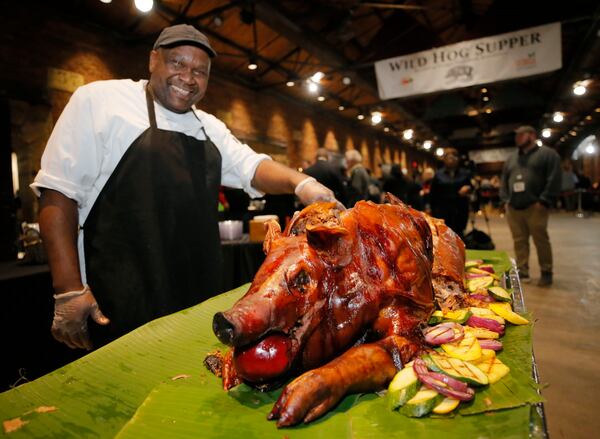 Richard Adams carves up some wild hog Sunday at the Wild Hog Supper, which kicked off this year’s session of the General Assembly on Sunday. BOB ANDRES /BANDRES@AJC.COM