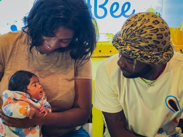 Alandria Worthy (left) and Deandre Phillips with their daughter at a baby shower at a McDonald's on Fulton Industrial Boulevard.