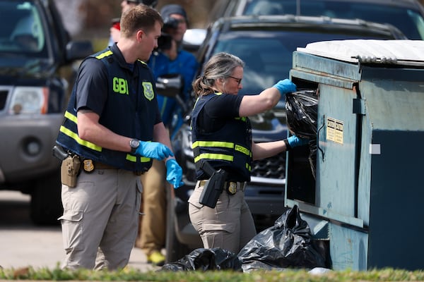 GBI officers search a dumpster across the street from the Cielo Azulak Apartments, Friday, Feb. 23, 2024, in Athens, Ga. (Jason Getz / jason.getz@ajc.com)