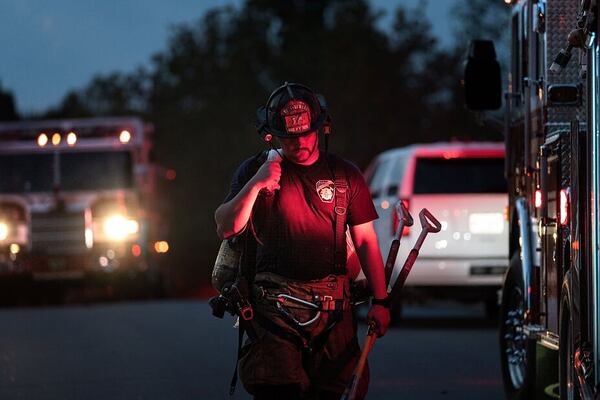 A Forsyth County firefighter works outside a home where two children were killed in a fire.