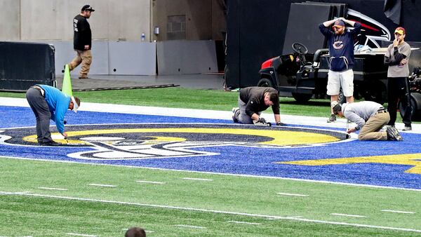 Workers paint the Rams logo in the end zone at Mercedes-Benz Stadium in preparation for Super Bowl LIII on Tuesday, Jan. 22, 2019, in Atlanta.