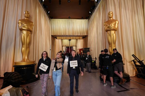 Stand-ins walk past Oscar statues in the red carpet area before the 97th Academy Awards in Los Angeles, Saturday, March 1, 2025. (AP Photo/Jae C. Hong)