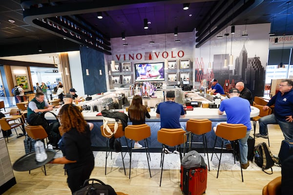 Travelers are seen dining at Vino Volo in the new location in Terminal T at Hartsfield-Jackson International Airport on Wednesday, May 1, 2024. Vino Volo is one of the shops opened this year by Paradies Lagardère. (Miguel Martinez/AJC)