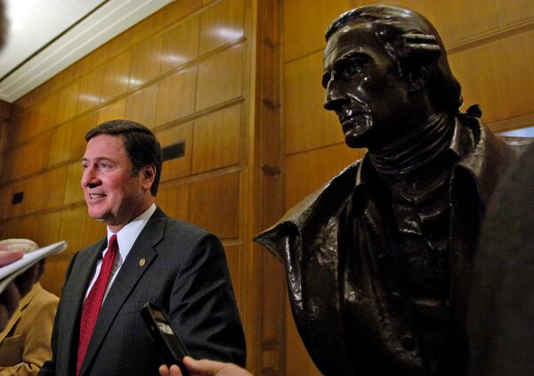 FILE - Sen. George Allen, R-Va., talks with the media as he stands beside a bust of Patrick Henry after Allen adressed the Republican caucus inside the Patrick Henry Building in Richmond, Va., Monday, on March 6, 2006. (AP Photo/Richmond Times-Dispatch, Bob Brown, File)