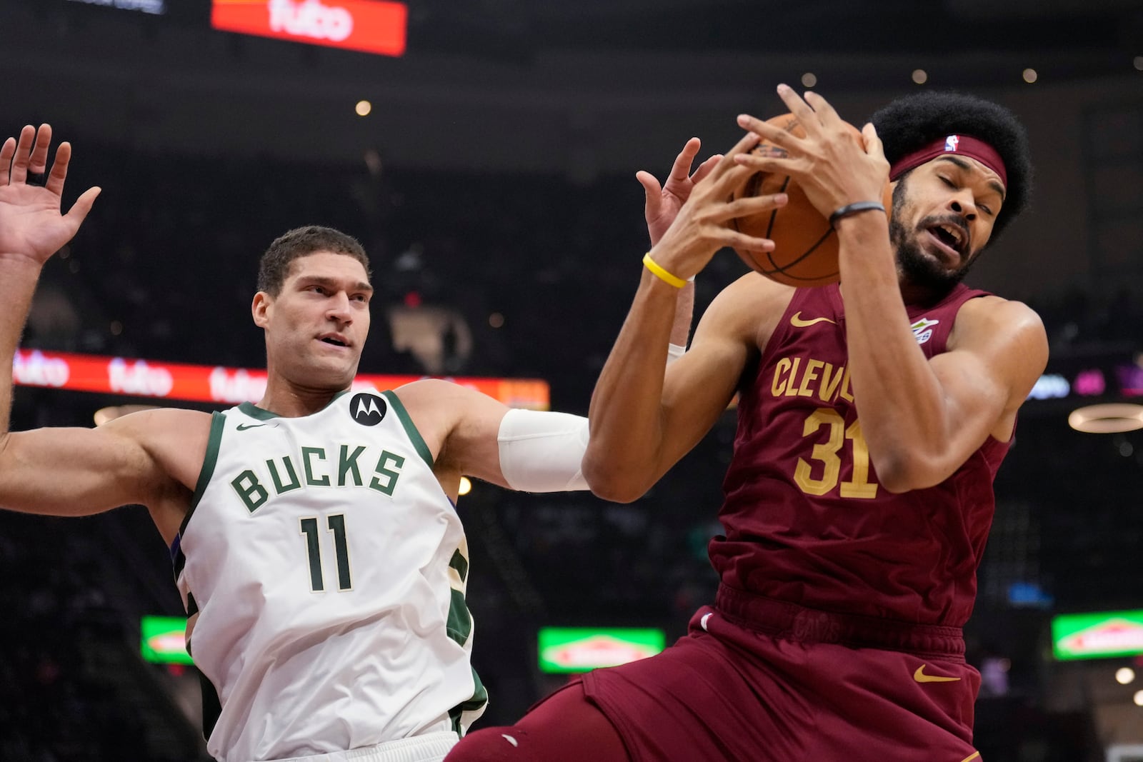 Cleveland Cavaliers center Jarrett Allen (31) grabs a rebound in front of Milwaukee Bucks center Brook Lopez (11) in the first half of an NBA basketball game, Monday, Nov. 4, 2024, in Cleveland. (AP Photo/Sue Ogrocki)