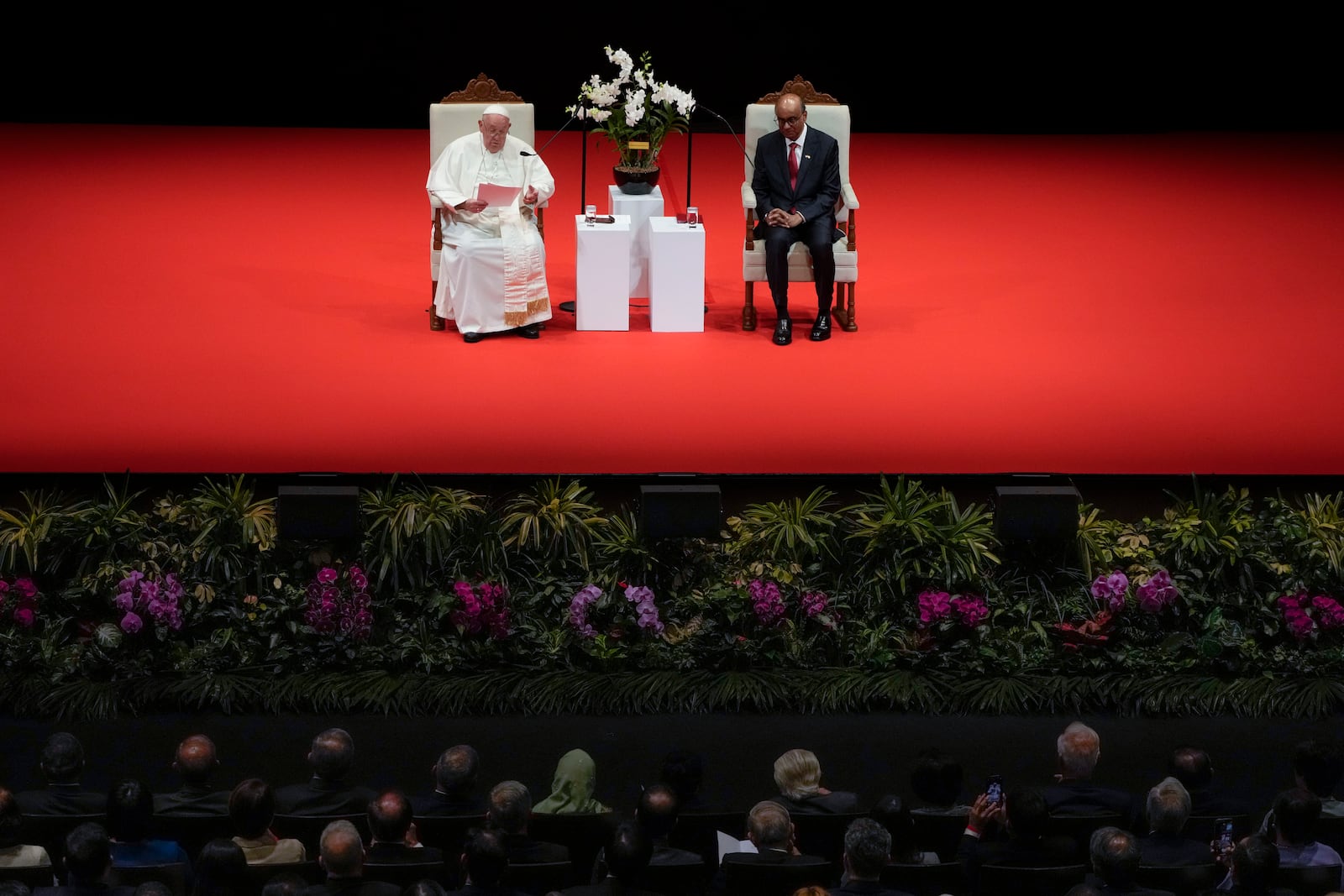 Pope Francis addresses Singapore's President Tharman Shanmugaratnam, right, and the audience during a meeting with the authorities, civil society and the diplomatic corps in the theatre of the Cultural Centre of the National University of Singapore, Thursday, Sept. 12, 2024. Pope Francis flew to Singapore on Wednesday for the final leg of his trip through Asia, arriving in one of the world's richest countries from one of its poorest after a record-setting final Mass in East Timor. (AP Photo/Gregorio Borgia)