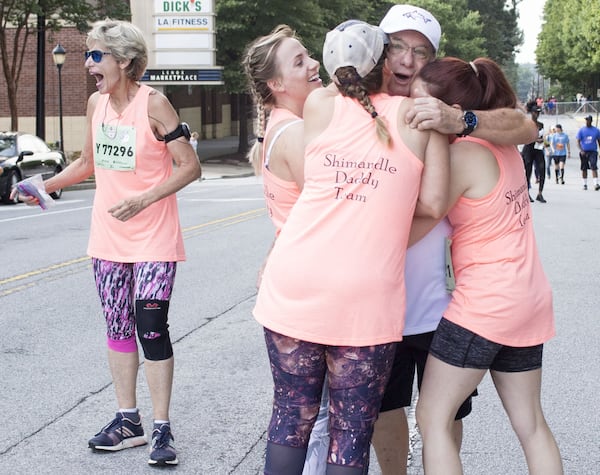 July Fourth was a time for family and surprises at the AJC Peachtree Road Race for Rick Shimandle. With him here are his wife, Adie (left), and three of his daughters: Kennsington Jones (second from left), Teanna Wilson (center) and Alexandria Wilhite. JENNA EASON / JENNA.EASON@COXINC.COM