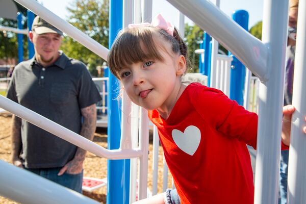 Mike Raines watches as he daughter Raven plays at the Alpharetta Elementary School playground with her family. Raven was born almost 5 years ago with a severe congenital heart defect. In her short life, she's survived nine surgeries Ð six of them open-heart surgeries Ð and has spent much of her first three years of life in a hospital. Throughout this ordeal, the family received an outpouring of help from the Alpharetta community. Though still with special needs, Raven is now healthy and will celebrate her 5th birthday Dec. 10. PHIL SKINNER FOR THE ATLANTA JOURNAL-CONSTITUTION.