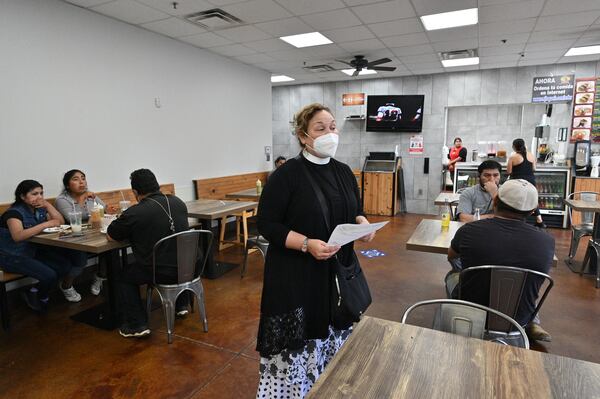 The Rev. Irma Guerra, holding COVID-19 vaccine pamphlets, encourages members of the Hispanic community to get the vaccine. She's making her appeal at the food court of Super Mercado Jalisco supermarket in Norcross on Wednesday, Aug. 11, 2021. (Hyosub Shin / Hyosub.Shin@ajc.com)