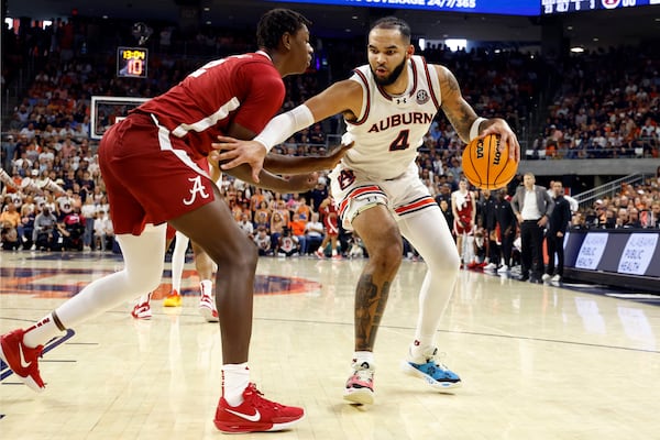 Auburn forward Johni Broome (4) dribbles around Alabama forward Aiden Sherrell (22) during the second half of an NCAA college basketball game, Saturday, March 8, 2025, in Auburn, Ala. (AP Photo/Butch Dill)