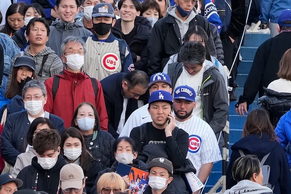 Fans of the Chicago Cubs and the Los Angeles Dodgers walk around the Tokyo Dome ahead of an MLB Tokyo Series baseball game between the Los Angeles Dodgers and the Chicago Cubs, in Tokyo, Tuesday, March 18, 2025. (AP Photo/Shuji Kajiyama)