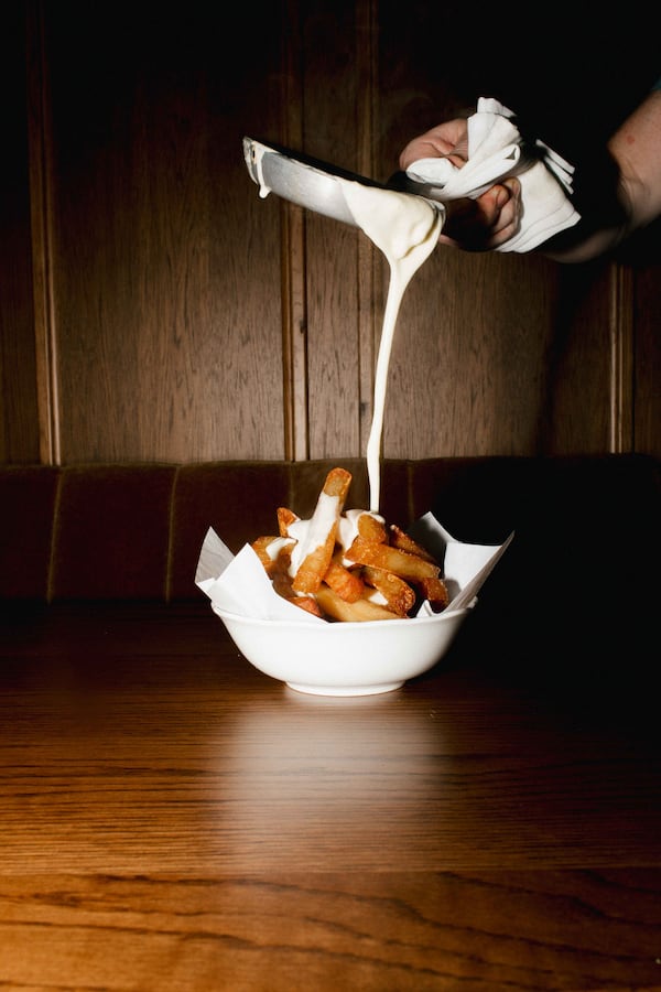 Little Sparrow offers tableside raclette service, which sees melted, bubbling Alpine cheese poured over frites . / Courtesy of Little Sparrow