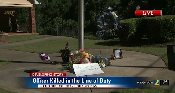 Mourners left flowers, a wreath and a poster outside Holly Springs police headquarters following the young officer's death.