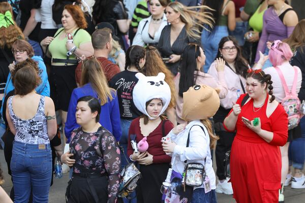 Wearing a white rabbit hat, Brittani Thomas of North Carolina and Lily Guffey of Mississippi, wearing a puppy hat, line up outside of State Farm Arena before the K-Pop band Stray Kids concert in March. Jason Getz / Jason.Getz@ajc.com)
