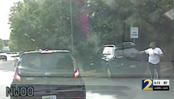 This is a screenshot of police dashcam video that shows the wrecked vehicles at the intersection of Peachtree Industrial Boulevard and Pleasant Hill Road. 