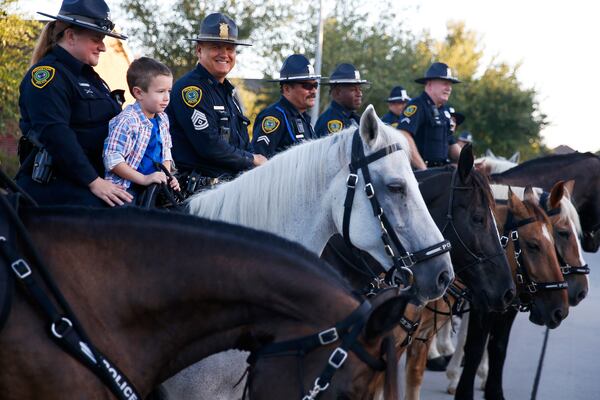 Kevin Will Jr., 5, the son of slain Houston police officer Kevin Will, sits on top of a horse as he is escorted to his first day of school by Houston police and other officers Tuesday, Aug. 22, 2017 in Cypress, Texas.  Officer Kevin Will died in May 2011 after being hit by a vehicle at the scene of an unrelated wreck. His wife was pregnant at the time. 