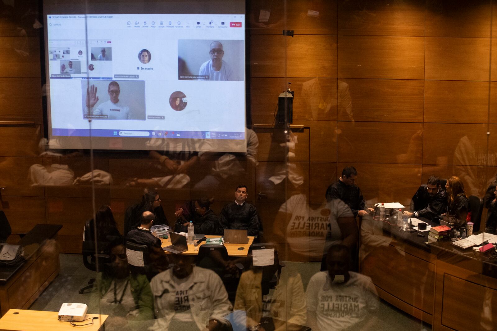 Former military police officers, shown on screen, from left, Ronnie Lessa and Elcio Queiroz attend via video conference their trial where they are accused of murdering city councilwoman Marielle Franco and driver Anderson Gomes, at the Court of Justice in Rio de Janeiro, Wednesday, Oct. 30, 2024. (AP Photo/Bruna Prado)