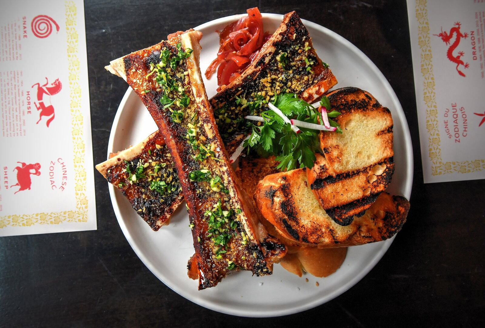 Roasted Bone Marrow, onion jam, gremolata, panko, radish salad, served with baguette. CONTRIBUTED BY CHRIS HUNT PHOTOGRAPHY