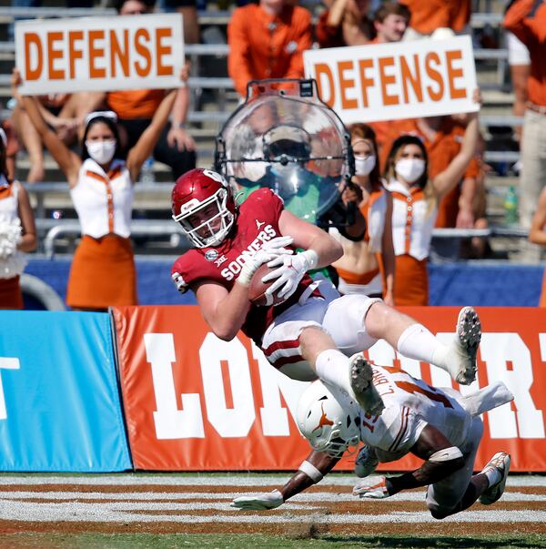 Oklahoma running back Austin Stogner (18) flies through the air as he makes a leaping catch in front of Texas defensive back Chris Brown (15) during the third quarter at the Cotton Bowl in Dallas on Saturday, Oct. 10, 2020. Oklahoma won in quadruple overtime, 53-45. (Tom Fox/Dallas Morning News/TNS)