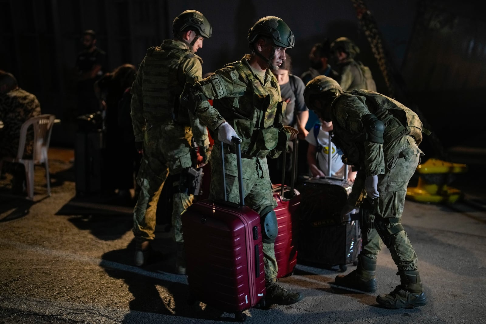 Turkish military personnel carry luggage of Turkish citizens to be evacuated on Turkish military ships from Lebanon to Turkey, in Beirut port, Wednesday, Oct. 9, 2024. (AP Photo/Emrah Gurel)