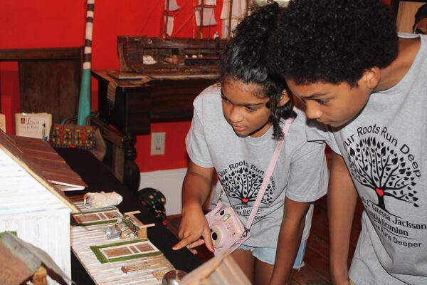 Grace and Solomon Pearce, descendants of former slaves, Jacob and Taressa Jackson, look at a replica of slave quarters in the Eugene Swain Exhibit at the Morgan County African-American Museum. (Photo Courtesy of Emily Whitten)