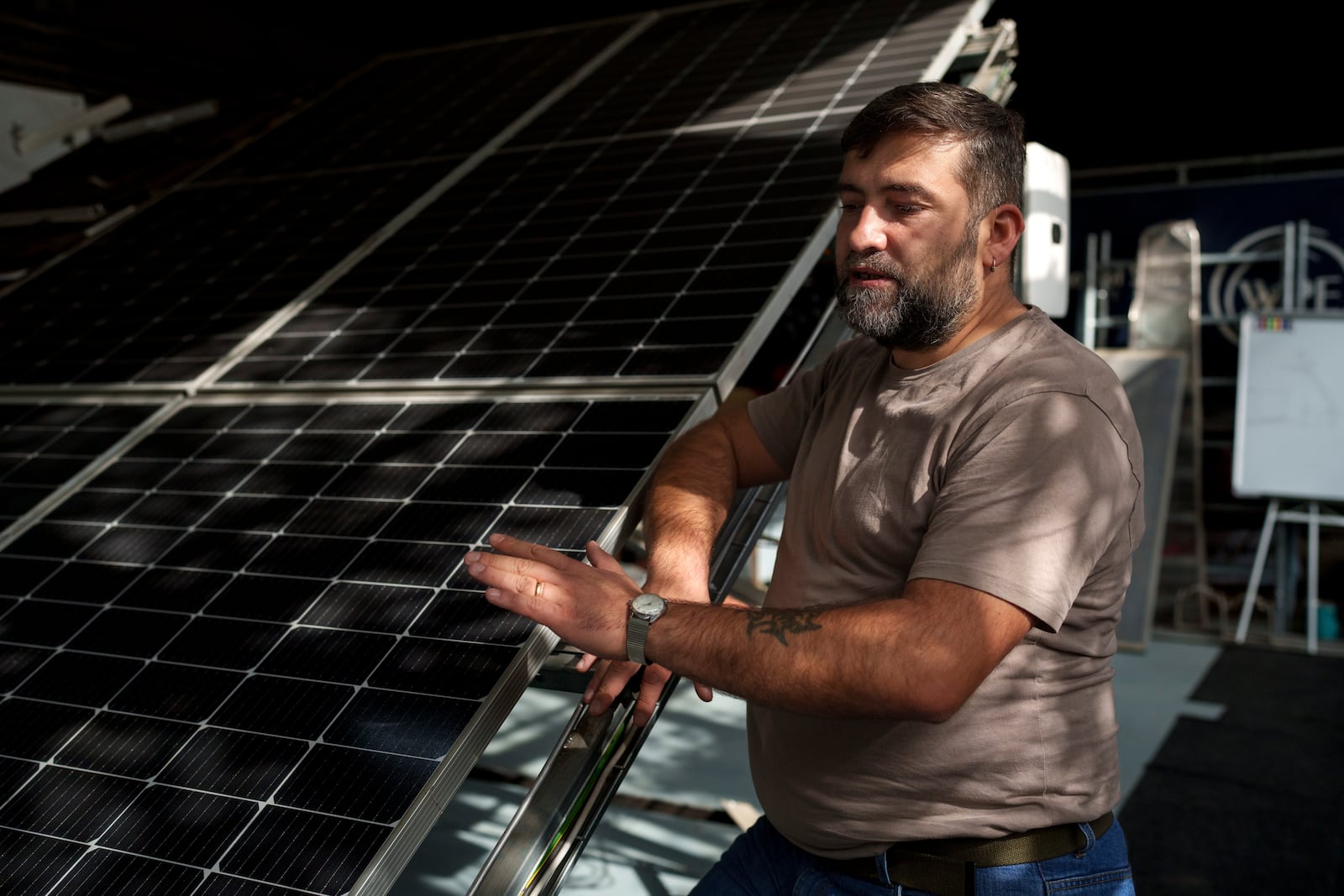 Sebastian Tirintica speaks next to solar panels in the RenewAcad training center in Petrosani, southern Romania, Friday, Oct. 11, 2024. (AP Photo/Vadim Ghirda)