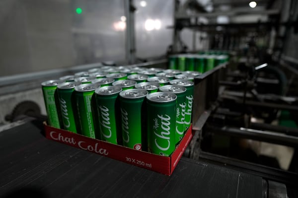 Completed aluminum cans of the Chat Cola Company brand Chat Apple carbonated soft drink move along a production line in the Palestinian company's bottling plant, in the West Bank city of Salfit, Feb. 13, 2025. (AP Photo/Nasser Nasser)