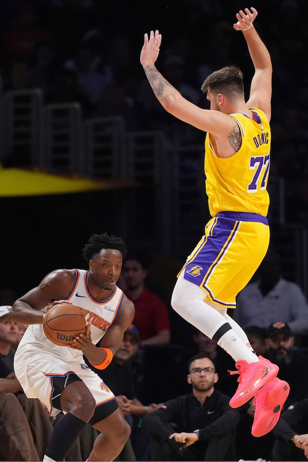 New York Knicks forward OG Anunoby, left, tires to pass as Los Angeles Lakers guard Luka Doncic defends during the first half of an NBA basketball game Thursday, March 6, 2025, in Los Angeles. (AP Photo/Mark J. Terrill)