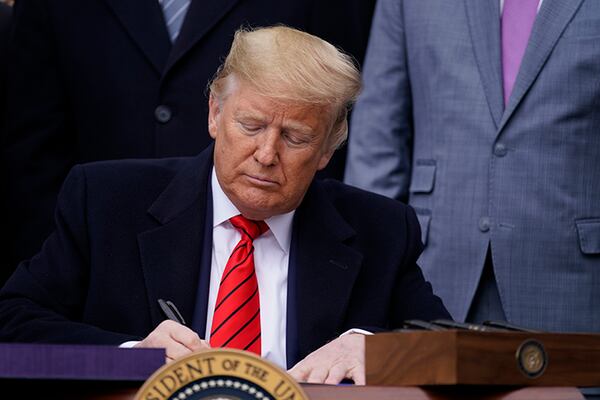 President Donald Trump signs a new North American trade agreement with Canada and Mexico on Wednesday at the White House.