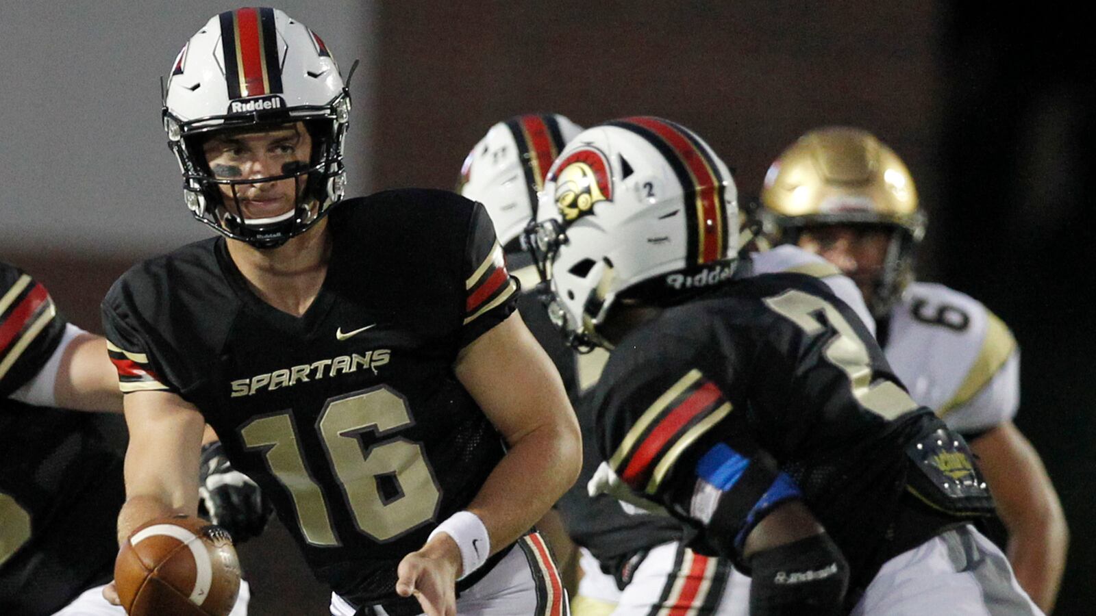 Greater Atlanta Christian Spartans quarterback Davis Mills (16) hands off to Kyler McMichael during play against St. Piux X at Spartan Stadium Friday, Sept. 16, 2016. (Tami Chappell/Special to AJC)