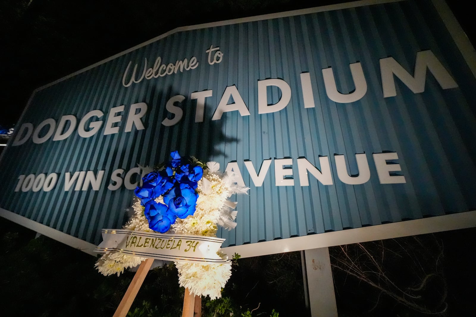 A flower arrangement honoring former Los Angeles Dodgers pitcher Fernando Valenzuela is seen near the entrance to Dodger Stadium, Tuesday, Oct. 22, 2024 in Los Angeles. Valenzuela, the Mexican-born phenom for the Los Angeles Dodgers who inspired "Fernandomania" while winning the NL Cy Young Award and Rookie of the Year in 1981, has died Tuesday, Oct. 22, 2024. (AP Photo/Julio Cortez)