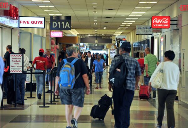 June 24, 2014 Atlanta - Airport travelers walk past one of newer restaurants, Five Guys, in Concourse D, Hartsfield-Jackson Atlanta International Airport on Tuesday, June 24, 2014. Hartsfield-Jackson and Delaware North celebrate the newest additions to Concourse D, including local favorites GrindHouse Killer Burgers and Yoforia, and national brands 40/40 Club and Food Network Kitchen. HYOSUB SHIN / HSHIN@AJC.COM