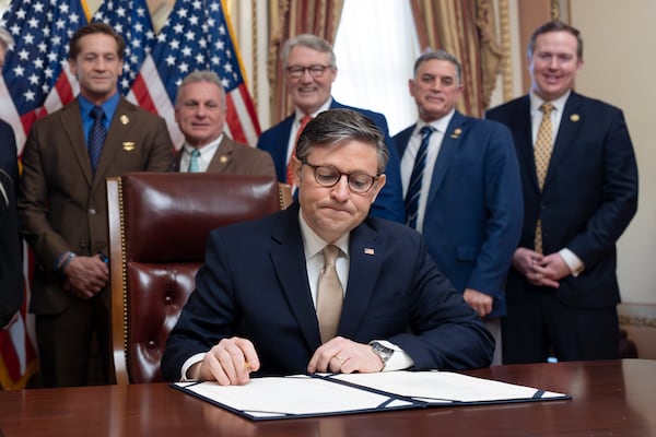 House Speaker Mike Johnson, R-La., puts his signature on the Laken Riley Act with members of the Georgia congressional delegation attending, at the Capitol in Washington, Thursday, Jan. 23, 2025. (AP Photo/J. Scott Applewhite)