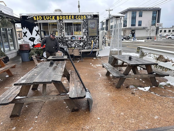 Andy Atkins removes snow from the outdoor seating area for his food truck Bad Luck Burger Club in Nashville, Tenn. on Saturday, Jan.11, 2025. (AP Photo/Kristin M. Hall)