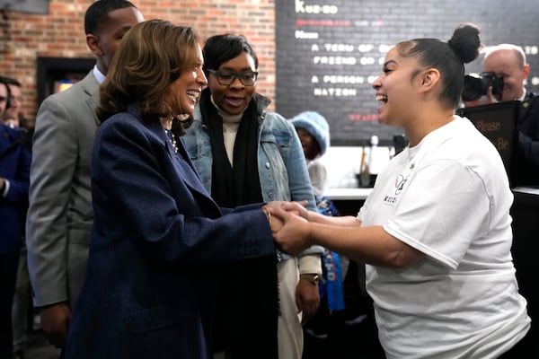 Democratic presidential nominee Vice President Kamala Harris, left, greets a member of the restaurant staff during a campaign stop at Kuzzo's Chicken and Waffles in Detroit, Sunday, Nov. 3, 2024. (AP Photo/Jacquelyn Martin)