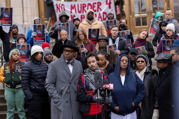 Justin Taylor Garrett (center), the son of Cornelius Taylor, speaks during a protest in front of City Hall in Atlanta on Jan. 23. Taylor was killed when the city cleared the encampment he lived in last week. (Arvin Temkar/AJC)